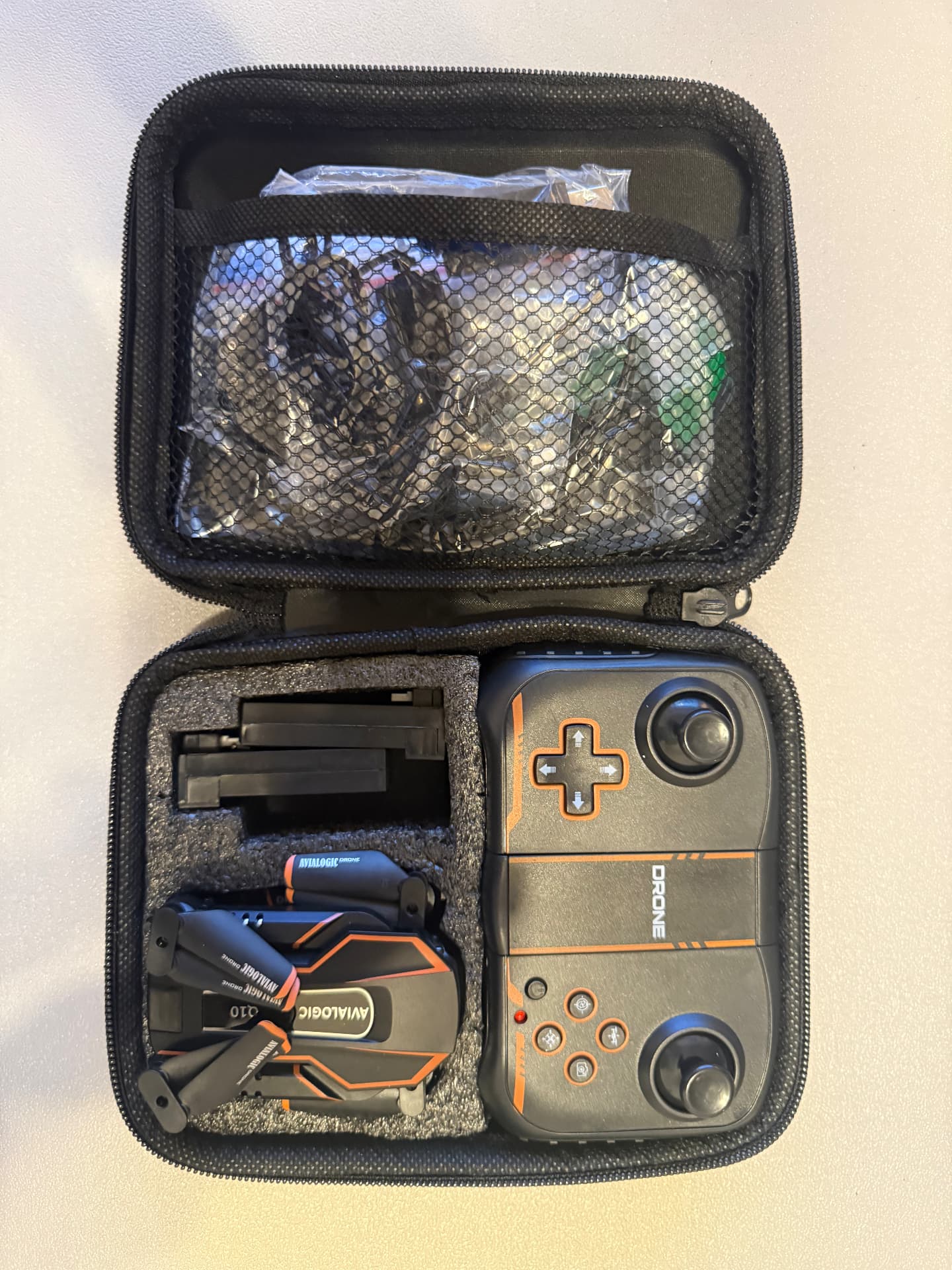 Hard case holding the Q10 drone folded, its controller, spare props, and cables