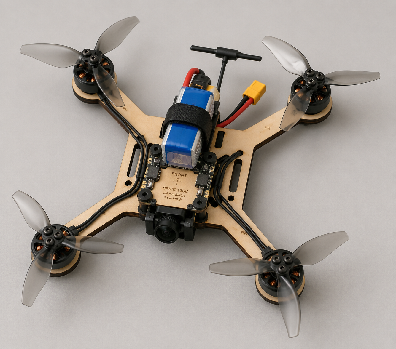 SPRIG-120C mini quadcopter assembled on a birch frame with motors, props, FPV camera, flight controller, and LiPo battery
